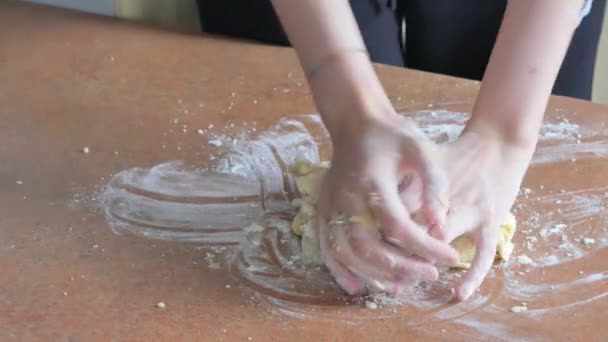 Mâinile feminine frământând aluatul în făină pe masă — Videoclip de stoc