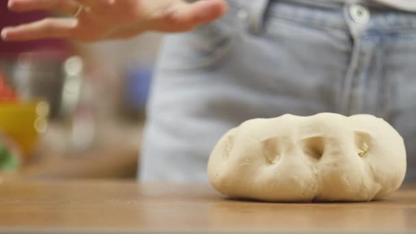 Wanita di meja dapur membuat pizza makanan domestik, tangan bekerja dan mendorong aduk adonan, selektif fokus boneka ditembak — Stok Video