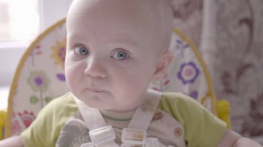 Masadaki küçük güzel çocuk eline bir kurabiye aldı, yedi ve kameraya doğru izledi. Yavaş çekim videosu 4K 'de.