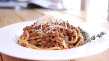 Tahta masada duran biberiyeli parmesan peynirli bir tabak bolonez makarna.