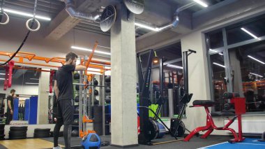 Spor kıyafetleri içinde spor salonunda spor salonunda ağır tıp topuyla egzersiz yapan güçlü genç bir adam. Çapraz antrenman yapan bir adam. - Evet. Kapat.