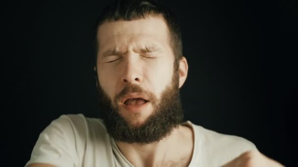 Fehér férfi szakállal a könyökébe tüsszent. Helyes tüsszentési technika. Allergiás reakció, légzőszervi betegségek tünetei. Vírus, járvány, karantén — Stock videók