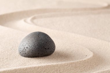 Çizgi desenli kumlu plaj kumüzerinde siyah bazalt taş. Spa sağlıklı yaşam veya zen meditasyon bahçe arka plan.
