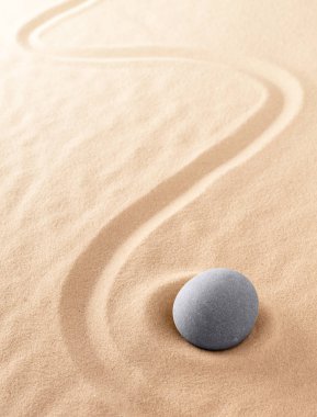 Zen meditasyon taşı odaklanmak ve sakin bir zihin huzuru için konsantre olmak için. Ruhani tırmıklanmış kum arkaplan dokusu. Uyum, saflık ve maneviyat kavramı.