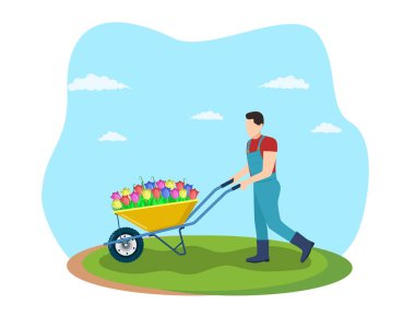 Bahçe el arabası ve bahar çiçekleri.