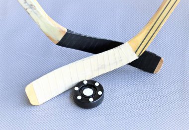 İç hokey diski ve hokey sopaları gri arkaplanda
