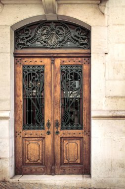 Antika ahşap kapı ile metal kafes içinde taş ev inşa