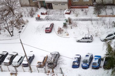 Yukarıdan arabalar kar yağışı kar ile kaplı sonra binanın konut mekâna görüntüleyin. Seçici odak