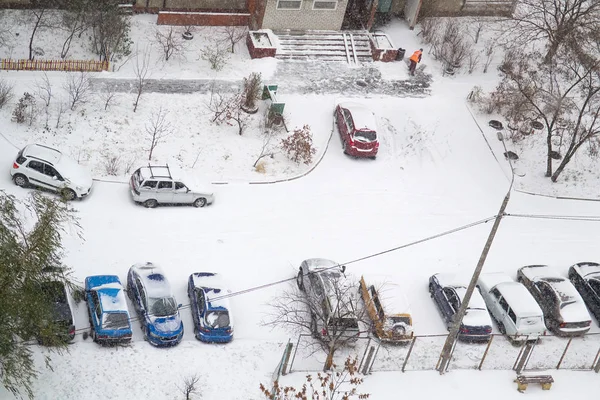 Yukarıdan arabalar kar yağışı kar ile kaplı sonra binanın konut mekâna görüntüleyin. Seçici odak
