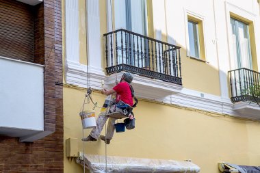 Worker paints the wall of a residential house