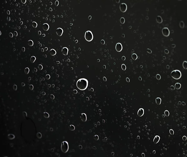 Капли воды на черном стекле — стоковое фото