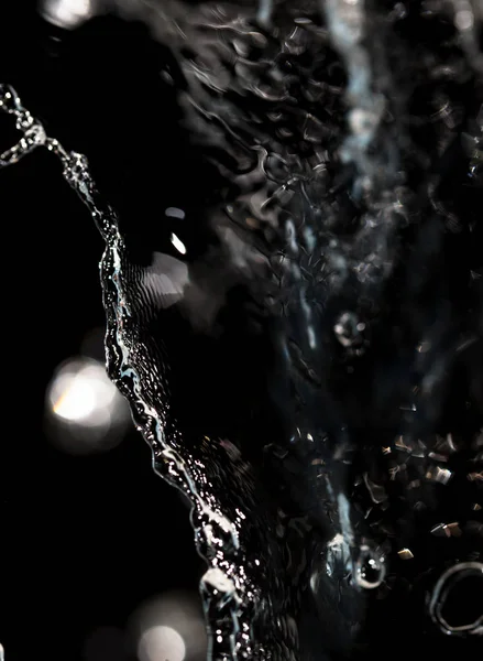Pulverizar água sobre um fundo preto — Fotografia de Stock