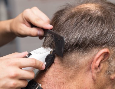 saç kesme makineleri ile bir saç kesimi olan bir erkek öğrencinin yakın çekim