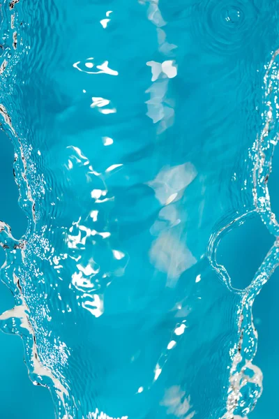 Wasserspritzer auf blauem Hintergrund — Stockfoto