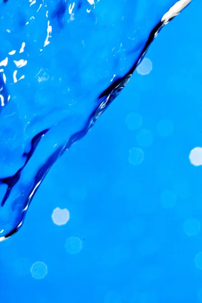 Bela água em um fundo azul — Fotografia de Stock