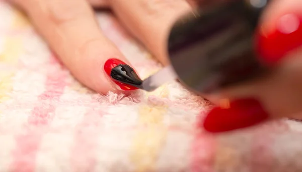Ногти окрашены в красный лак для ногтей в салоне красоты — стоковое фото