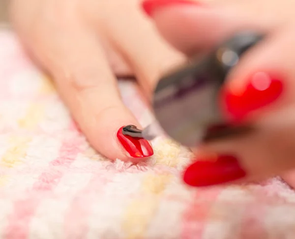 Nägel mit rotem Nagellack in Schönheitssalon lackiert — Stockfoto