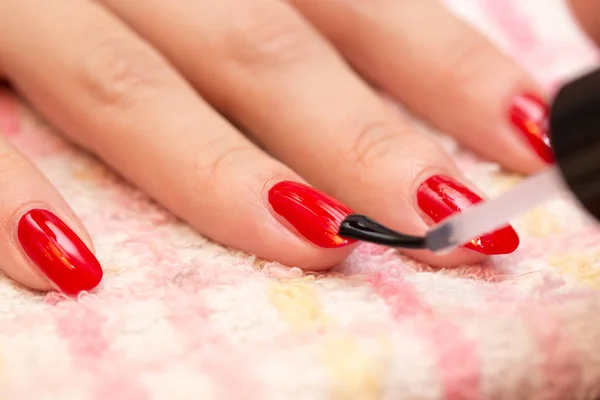 Unhas pintadas de esmalte vermelho em um salão de beleza — Fotografia de Stock