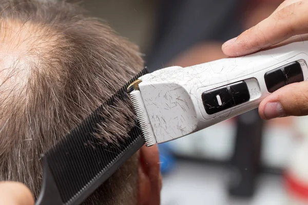 Hombre que tiene un corte de pelo con un cortador de pelo —  Fotos de Stock