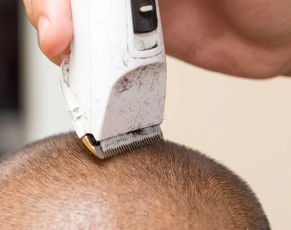 Hombre que tiene un corte de pelo con un cortador de pelo —  Fotos de Stock