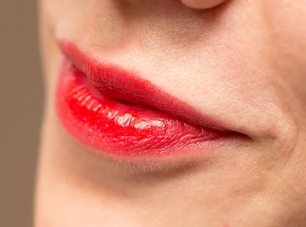 Close-up de lábios de mulher com batom vermelho brilhante — Fotografia de Stock