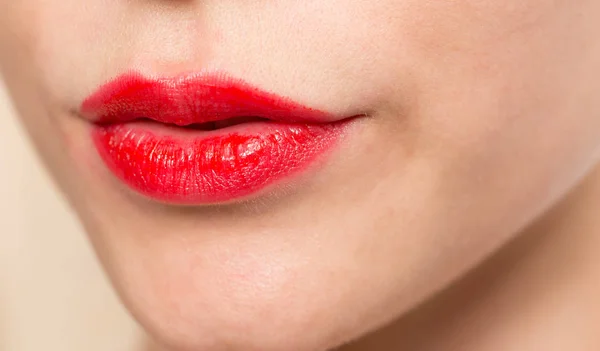 Close-up shot van vrouw lippen met glanzende rode lippenstift — Stockfoto