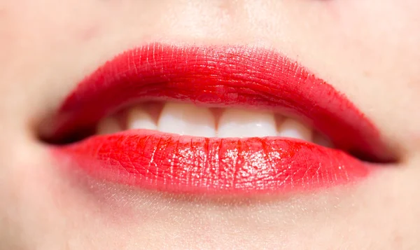 Крупный план женских губ с глянцевой красной помадой — стоковое фото
