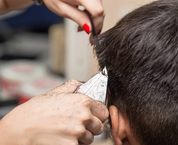 Homem com um corte de cabelo com um cortador de cabelo — Fotografia de Stock