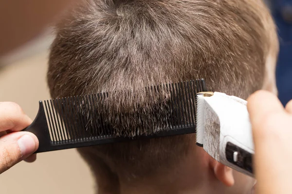 Homem com um corte de cabelo com um cortador de cabelo — Fotografia de Stock