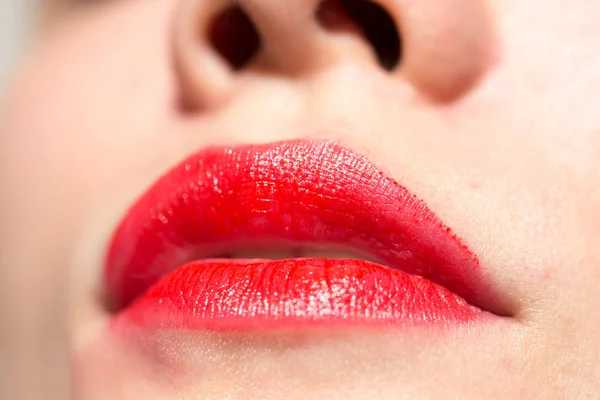 Primer plano de los labios de la mujer con lápiz labial rojo brillante —  Fotos de Stock