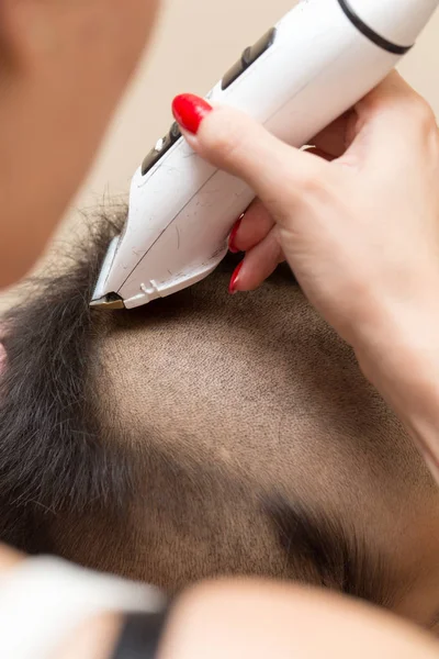 Homem com um corte de cabelo com um cortador de cabelo — Fotografia de Stock