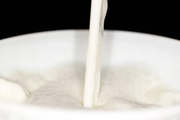 Salpicadura de leche sobre fondo negro —  Fotos de Stock