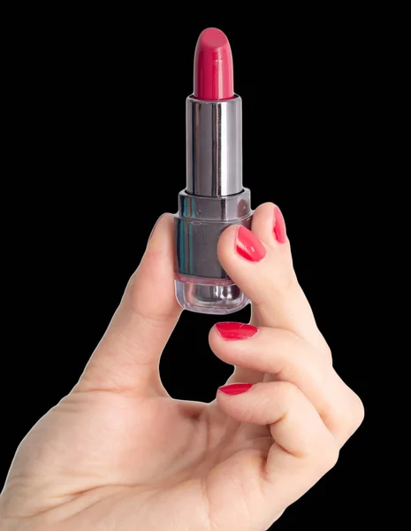 Rode lippenstift in hand met rode nagellak op een zwarte achtergrond — Stockfoto