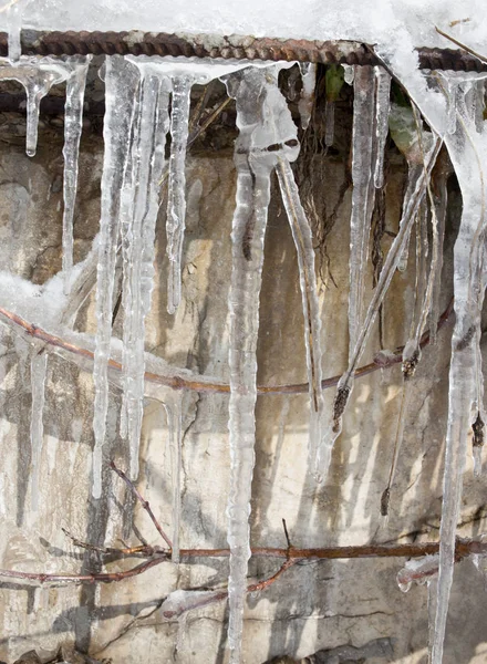 Large icicles hanging on the roof of the house in springtime — Stock Photo, Image