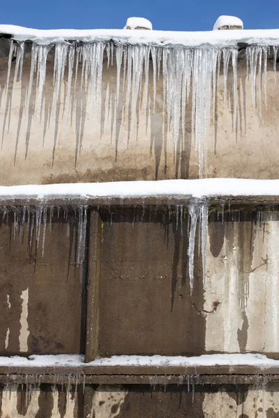 Baharda evin çatısında büyük buz sarkıtları asılı. — Stok fotoğraf