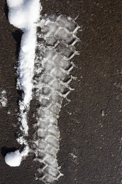 汽车在雪地上的痕迹与沥青 — 图库照片