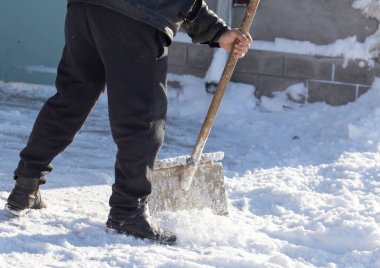 İşçi kar küreği temizler