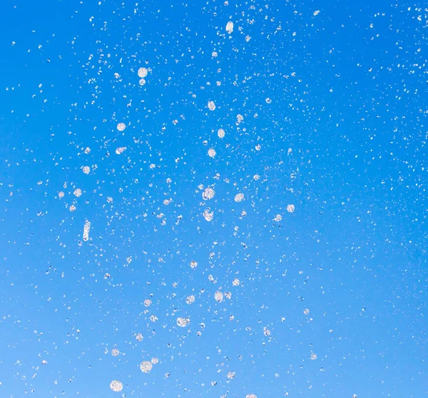 Agua salpicando de la fuente en el fondo del cielo azul —  Fotos de Stock