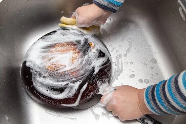 Menino lavar pratos na cozinha — Fotografia de Stock
