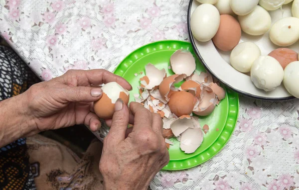 Granny cleans eggs — Stock Photo, Image