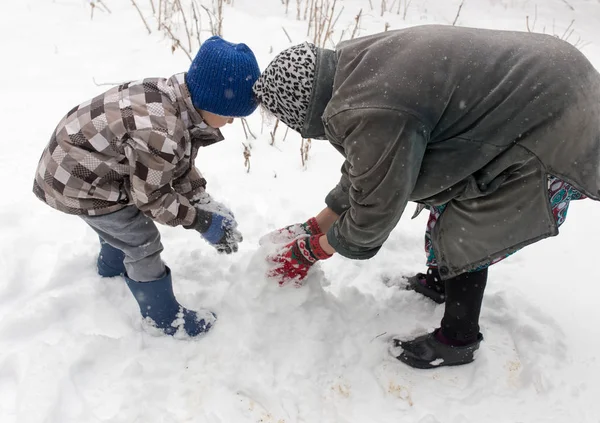 A boy with his grandmother playing in the snow — Stock Photo, Image