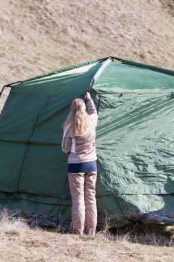 Kız bir çadır doğa üzerinde koyar.