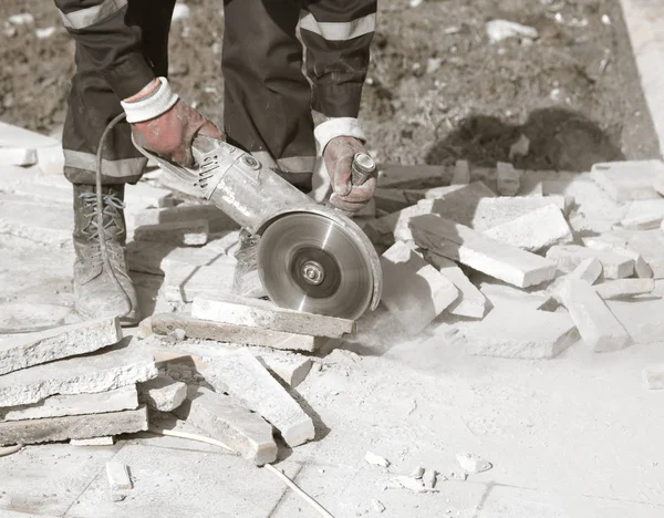 Worker cuts paving slabs — Stock Photo, Image