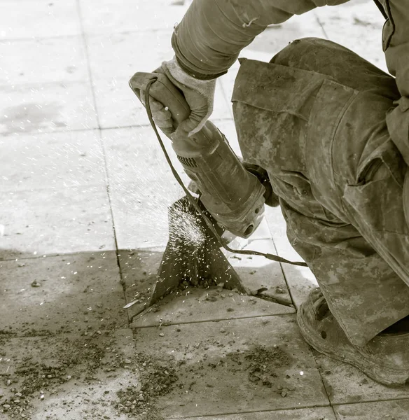 Arbetaren klipper metall i parken — Stockfoto