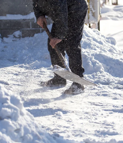 Trabajador limpia pala de nieve — Foto de Stock