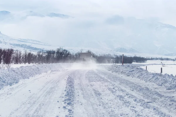 Strada nella neve ai piedi delle colline — Foto Stock