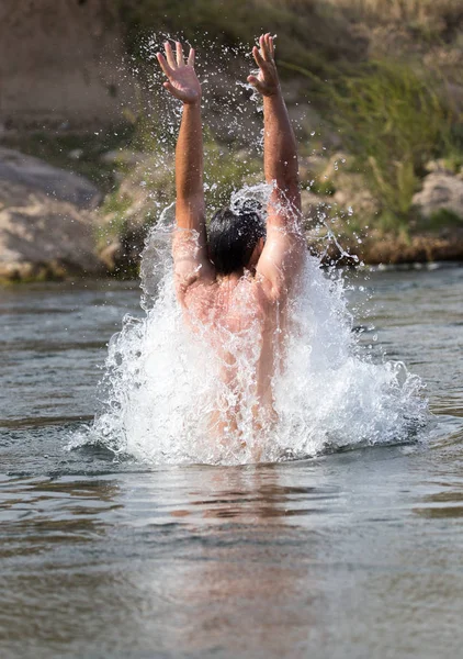 Een man springt uit het water — Stockfoto