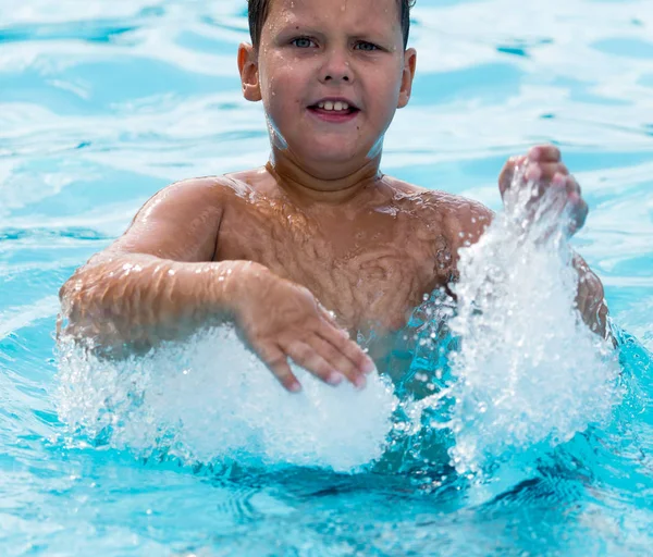 Pojken simmar i poolen — Stockfoto