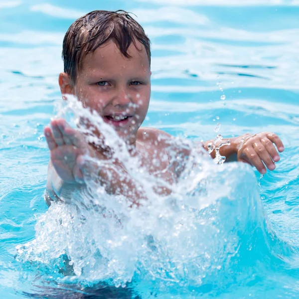 Pojken simmar i poolen — Stockfoto