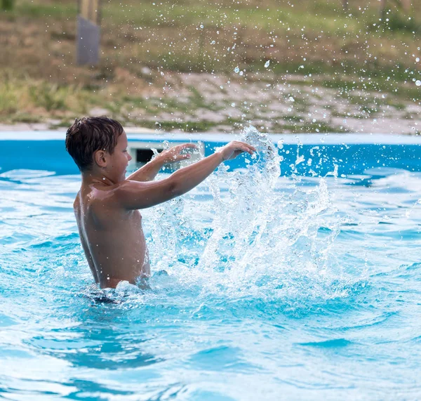 Çocuk havuzda yüzüyor. — Stok fotoğraf